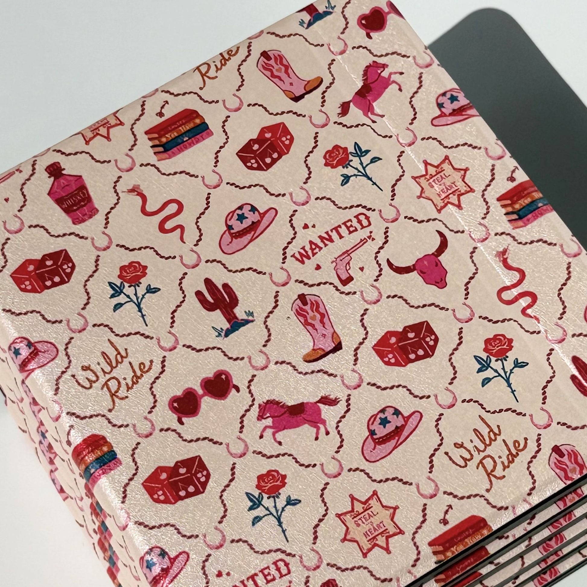 Pair of Wild Ride Kobo Libra cases stacked, pink cowgirlcore design with cowboy hats, dice, snakes and 'WANTED' sheriff stars