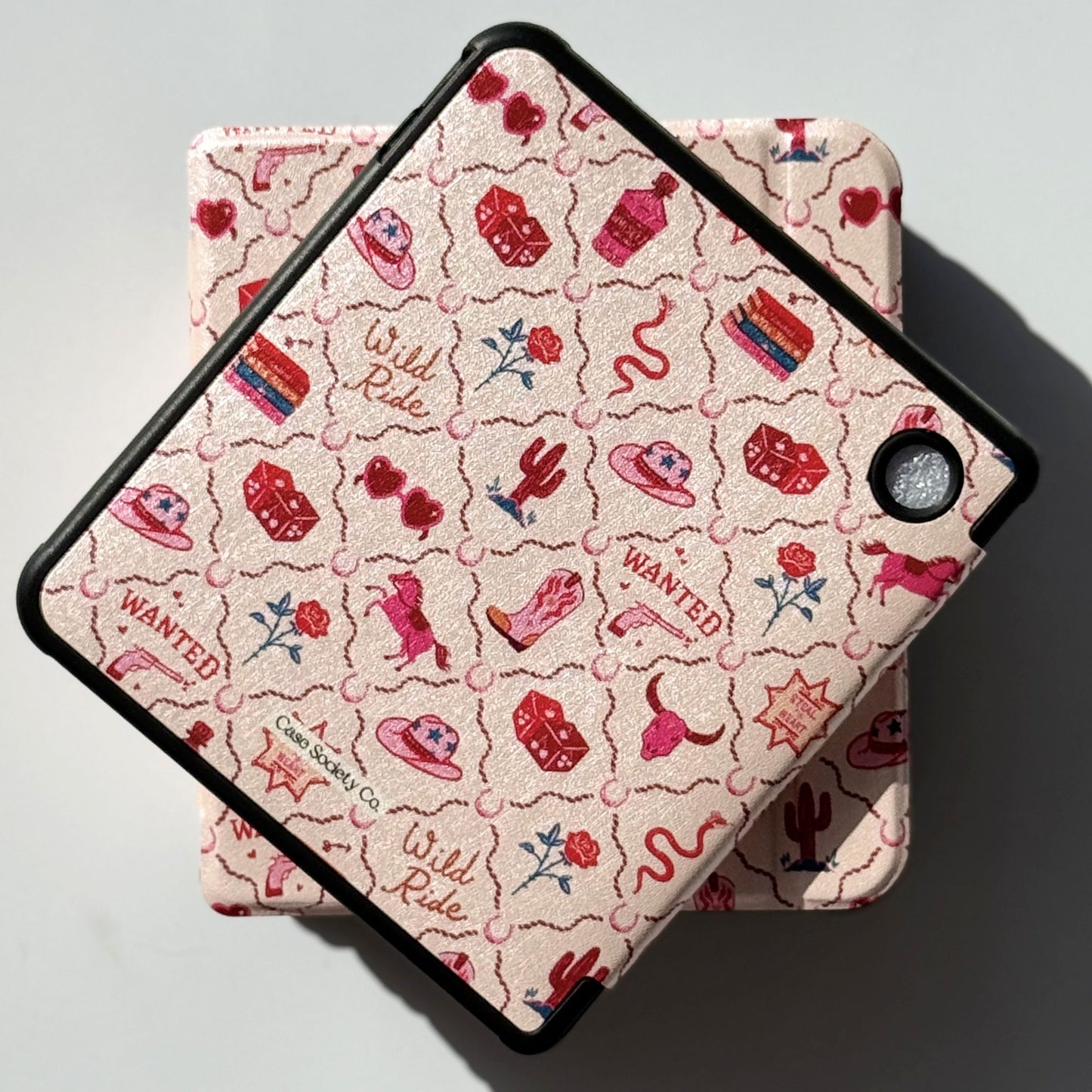 Side profile of Wild Ride Kobo Libra cases stacked, pink coastal cowgirl print spine detail with black shockproof bumper corners